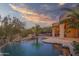 Expansive pool and patio with a waterfall feature at sunset at 44710 N 18Th St, New River, AZ 85087