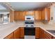 Kitchen features oak cabinets, a white stove, and a microwave at 6610 S 25Th Ave, Phoenix, AZ 85041