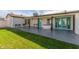 Large backyard with patio, grassy area, and teal doors at 6808 E Loma Land Dr, Scottsdale, AZ 85257