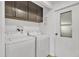 Bright laundry room with white washer and dryer, and dark brown cabinets at 7648 E Holmes Ave, Mesa, AZ 85209