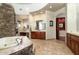 Spa-like bathroom featuring a stone wall, jetted tub, and dual sinks at 10630 E Cactus View Cir, Gold Canyon, AZ 85118