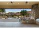 Outdoor kitchen with built-in grill, mini-fridge, and bar seating overlooking the pool at 10630 E Cactus View Cir, Gold Canyon, AZ 85118