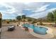 Relaxing kidney-shaped pool with a waterfall feature and patio seating at 10630 E Cactus View Cir, Gold Canyon, AZ 85118