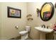 Elegant powder room with pedestal sink and decorative mirror at 10630 E Cactus View Cir, Gold Canyon, AZ 85118