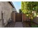 Backyard access with a brown wooden gate and stone pathway at 11047 E Tupelo Ave, Mesa, AZ 85212