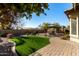 Landscaped backyard with artificial turf, gazebo, and brick pavers at 11047 E Tupelo Ave, Mesa, AZ 85212