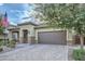 Brick paver driveway and one-story home with American flag at 11047 E Tupelo Ave, Mesa, AZ 85212