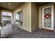 Covered front porch with two chairs and a fall wreath on the door at 11047 E Tupelo Ave, Mesa, AZ 85212