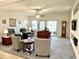 Bright living room featuring neutral tones, ceiling fan, and sliding glass door to the backyard at 11047 E Tupelo Ave, Mesa, AZ 85212