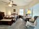 Inviting main bedroom with a ceiling fan, two comfortable chairs and large bright window at 11047 E Tupelo Ave, Mesa, AZ 85212