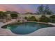 Inviting swimming pool with waterfall feature and surrounding landscaping at 12067 N 135Th Way, Scottsdale, AZ 85259