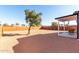 Sunny backyard with gravel ground cover, wood fence, and covered patio at 1217 S Desert View Pl, Apache Junction, AZ 85120