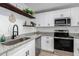 Modern kitchen with white cabinets, granite countertops, and stainless steel appliances at 1217 S Desert View Pl, Apache Junction, AZ 85120