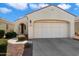 Beige house with a two-car garage and landscaped front yard at 12947 W Chapala Dr, Sun City West, AZ 85375