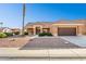 Tan house with brown roof, desert landscaping, and a two-car garage at 14203 W Rico Dr, Sun City West, AZ 85375