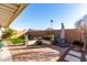 Landscaped backyard featuring a patio, fire pit, and grassy area at 15725 W Post Dr, Surprise, AZ 85374