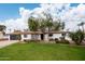 White single story home with a spacious lawn and mature trees at 1624 W Lawrence Rd, Phoenix, AZ 85015