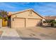 Two-car garage with tan stucco exterior and paved driveway at 16813 S 37Th Way, Phoenix, AZ 85048