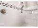 Clean shower with a built-in seat and mosaic tile details at 17502 W Blue Sky Dr, Surprise, AZ 85387