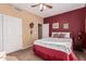 Charming bedroom with a red accent wall and ample closet space at 18354 W Hatcher Rd, Waddell, AZ 85355