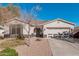 Single story home with two car garage and desert landscaping at 18354 W Hatcher Rd, Waddell, AZ 85355