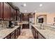 Spacious kitchen featuring granite countertops and dark wood cabinetry at 18354 W Hatcher Rd, Waddell, AZ 85355