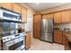 Modern kitchen featuring stainless steel appliances and wood cabinetry at 19475 N Grayhawk Dr # 2169, Scottsdale, AZ 85255