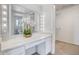 Bathroom with double vanity, large mirror, and walk-in closet at 19607 N Conquistador Dr, Sun City West, AZ 85375