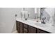 Double sink bathroom with dark brown vanity and updated fixtures at 19607 N Conquistador Dr, Sun City West, AZ 85375