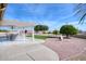 Covered patio with seating area, overlooking a grassy area and mature trees at 19607 N Conquistador Dr, Sun City West, AZ 85375