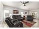 Living room with dark leather furniture, ceiling fan, and area rug at 22516 N Via De La Caballa --, Sun City West, AZ 85375