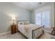 Bright bedroom with a metal bed frame, nightstand, and plantation shutters at 24435 S 195Th St, Queen Creek, AZ 85142