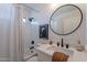 Clean bathroom with white vanity, round mirror, and bathtub at 2513 N 90Th Ln, Phoenix, AZ 85037