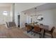 Bright dining room with wood table, leather chairs, and modern light fixture at 2513 N 90Th Ln, Phoenix, AZ 85037