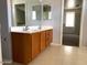 Clean bathroom with double vanity and wood cabinets at 25527 W Burgess Ln, Buckeye, AZ 85326