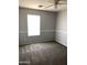 Bedroom with carpet, neutral walls, and large window at 25527 W Burgess Ln, Buckeye, AZ 85326