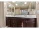 Double vanity bathroom with dark wood cabinets and a large mirror at 39979 W Robbins Dr, Maricopa, AZ 85138