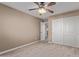 Bedroom with ceiling fan, wood-look floors and double door closet at 39979 W Robbins Dr, Maricopa, AZ 85138