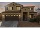 Two-story house with a brown double garage door and stone accents at 39979 W Robbins Dr, Maricopa, AZ 85138