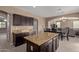 Kitchen boasts an island and ample dark wood cabinets at 39979 W Robbins Dr, Maricopa, AZ 85138