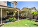 Covered patio, grassy area, and mature plants create a relaxing backyard space at 4407 E Villa Theresa Dr, Phoenix, AZ 85032