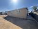 A neutral-colored home with a spacious dirt backyard with views of the exterior's simple architecture at 4854 W Berkeley Rd, Phoenix, AZ 85035