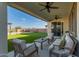 Covered patio with seating area, overlooking a grassy backyard and pool at 5629 S Veneto --, Mesa, AZ 85212