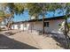 Spacious backyard with covered patio, gravel landscaping, and mature trees at 6409 W Orange Dr, Glendale, AZ 85301