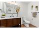 Modern bathroom with wood vanity, mirror, and toilet at 6409 W Orange Dr, Glendale, AZ 85301