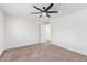 Spacious bedroom with ceiling fan, door to en-suite, and neutral carpet at 6409 W Orange Dr, Glendale, AZ 85301