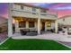 Wonderful backyard with a covered patio, artificial grass, and a beautiful sunset at 7409 W Briles Rd, Peoria, AZ 85383