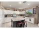 Modern kitchen with white cabinets, a large island, and tile backsplash at 7409 W Briles Rd, Peoria, AZ 85383