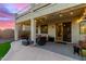 Covered patio with seating area and a view of the sunset and backyard at 7409 W Briles Rd, Peoria, AZ 85383