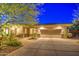 Night view of a single-story home with a large garage and nicely landscaped front yard at 7462 E Visao Dr, Scottsdale, AZ 85266